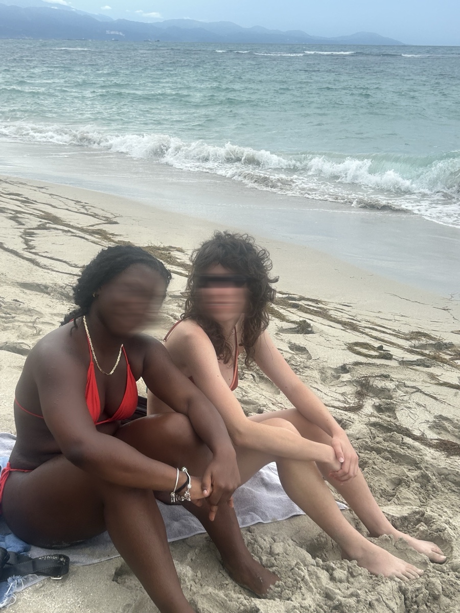 Side by side at the waterline, sea and coastline beyond, both faces motion-blurred
