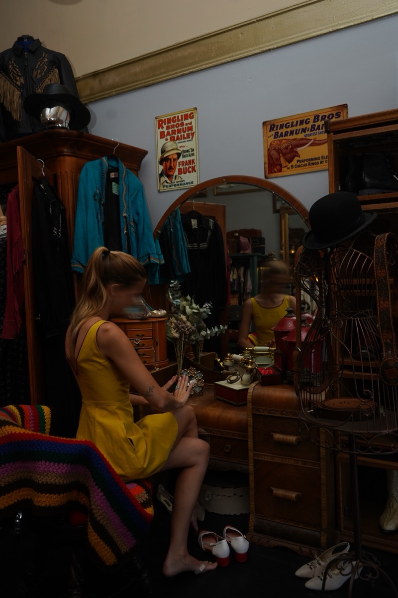 A woman at an antique vanity, shot from behind